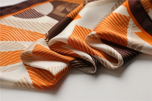 Detailed macro view of geometric pattern silk scarf showing smooth satin fabric texture