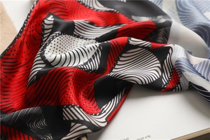 Detail of premium satin scarf showing colorful geometric patterns and silky texture