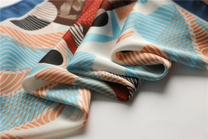 Macro detail of the silk scarf texture showing geometric patterns and orange wavy lines