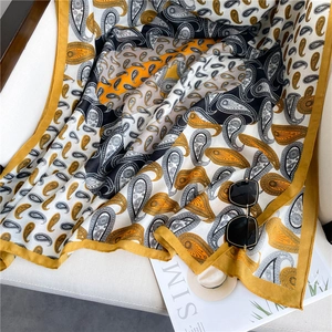 Classic paisley print cotton linen shawl with yellow borders on white chair
