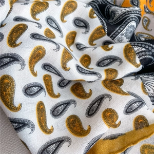 Close-up of yellow and black paisley cotton linen scarf with detailed fabric texture