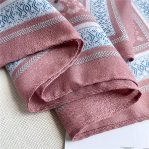 Dettaglio della trama geometrica rosa e blu dello scialle in cotone e lino morbido