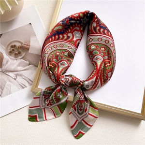 Elegant paisley silk scarf with colorful geometric patterns on a decorative gold frame