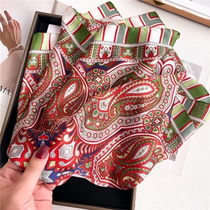 Detailed view of paisley silk scarf texture and vibrant ethnic patterns in red and green
