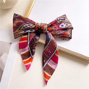 Bohemian paisley silk scarf bow tied elegantly on a neutral aesthetic background