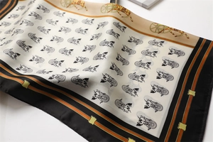 Detail eines luxuriösen Seidenschals mit Vintage-Kutschenmuster und orangefarbenem Rand