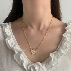Elegant gold flower necklace with cubic zirconia petals worn on a female model