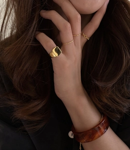 Detail shot of vintage square signet rings and tortoise shell resin bangle