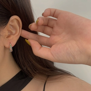 Close-up of rainbow micro-paved cubic zirconia huggie earrings on model ear