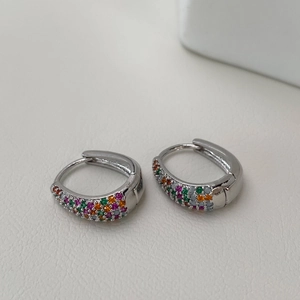 Close-up of geometric hoop earrings with colorful pavé micro-set cubic zirconia stones