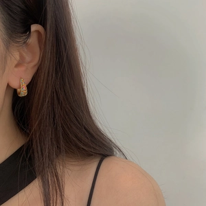 Minimalist gold-plated hoop earrings with multi-color cubic zirconia on a model