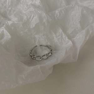 Dettaglio macro di un anello a catena industriale argento su sfondo di carta stropicciata