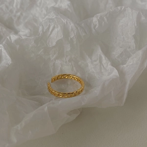 Dettaglio di un anello a catena dorato vintage su sfondo di carta velina bianca