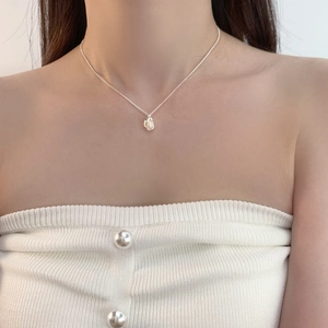 Close-up of minimalist silver chain necklace with a natural freshwater pearl pendant