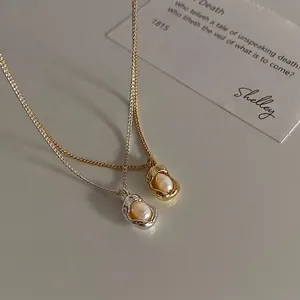 Lava-textured gold and silver necklaces with natural freshwater pearls on minimalist background