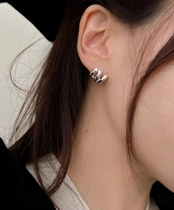 Close-up of three-layer silver wavy hoop earrings featuring a minimalist layered metal design