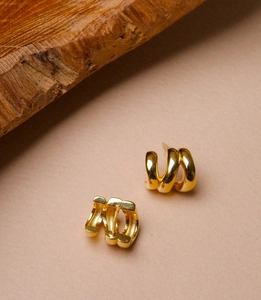 Detailed macro view of gold-plated triple-layer C-shaped hoop earrings with metal hallmark