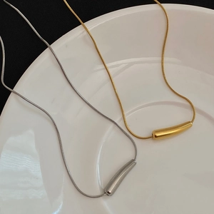 Details von unregelmäßigen Wassertropfen-Anhängern in Gold und Silber auf einem Schlangenband