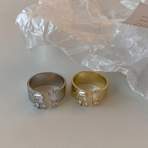 Detail of adjustable gold and silver rings set with sparkling zircon stones