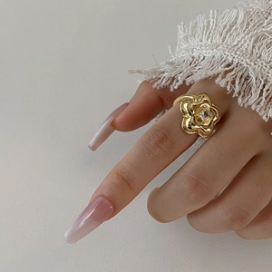 Macro detail of a gold flower ring with a square crystal on a woman's finger