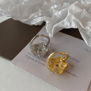 Macro view of flower-shaped adjustable rings in gold and silver with hammer texture detail