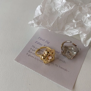 Detailed view of flower-shaped rings in gold and silver finish with square zircon inlay