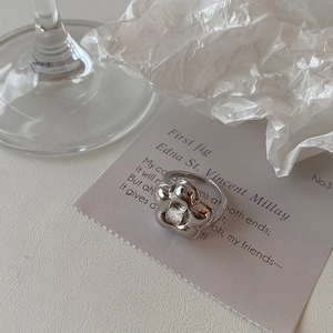 Macro shot of silver flower ring with a square zircon center and adjustable open band