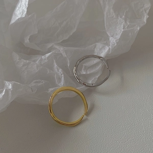 Detail of adjustable open rings with gold and silver lava texture on white background