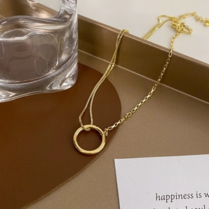 Elegant gold necklace with minimalist double-chain design and polished circular pendant