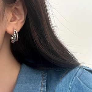 Detail of double-layer geometric metal and sparkling diamond-set C-shape hoop earrings