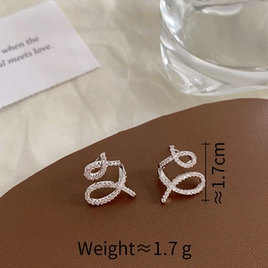 Detail shot of micro-paved zircon earrings with size specs on leather background