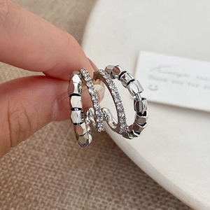 Detailed macro of silver layered geometric earrings with sparkling pavé crystal accents