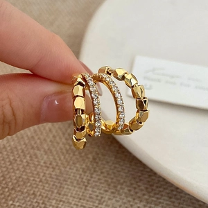 Macro shot of gold double-layer cubic zirconia ring with geometric faceted band detail