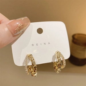 Detail of double-layer gold hoop earrings with sparkling zircons and faceted beads