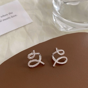 Detailed macro shot of criss-cross ribbon earrings with sparkling pavé cubic zirconia
