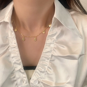 Minimalist gold-plated coffee bean link necklace on a model wearing a white silk shirt