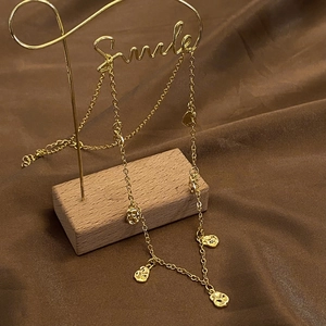Detail of gold coffee bean necklace with organic texture on vintage brown background