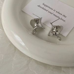 Macro shot of silver twisted hoop earrings with polished finish and S925 hallmark stamp