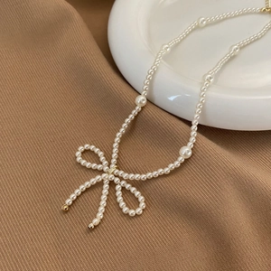 Vue détaillée du collier en perles fait main avec un nœud délicat et des glands élégants