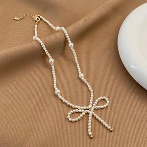 Élégant collier de perles fait main avec un pendentif nœud en perles et fermoir doré
