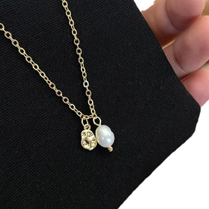 Natural freshwater baroque pearl necklace with gold-plated pendant on black fabric