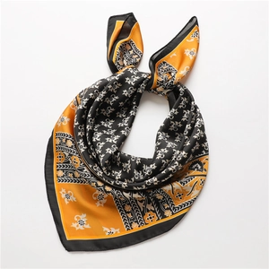 Carré de soie vintage aux motifs floraux et géométriques noir et orange, noué en ruban