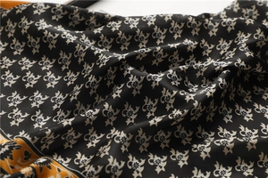 Détail d'un foulard en soie vintage aux motifs floraux dorés avec texture lisse