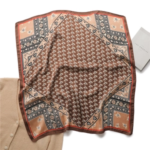 Gros plan détaillé du foulard en soie vintage avec motifs floraux et géométriques
