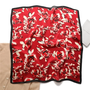 Detailed flat lay of a vintage red rose silk scarf with black borders on white background