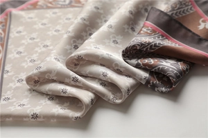 Gros plan sur la texture d'un foulard en soie vintage au lustre satiné et motifs rétro