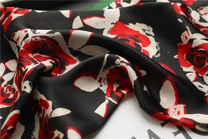 Macro shot of retro red rose pattern on silky satin scarf with smooth texture