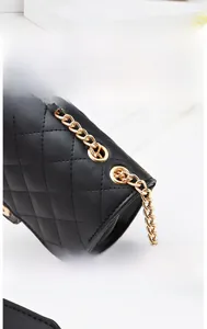 Détails de la chaîne dorée et des œillets sur un sac en cuir matelassé noir