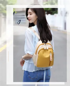 Detail of color-block Oxford backpack with heart-shaped zipper charm and side pocket