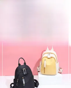 Detail view of mini nylon backpacks with multi-zipper pockets and contrast color design